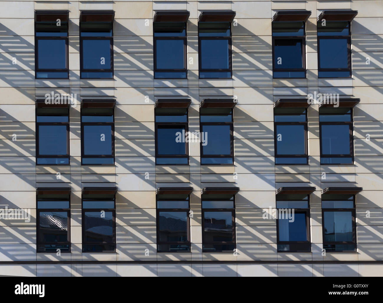 Luce e ombra su windows della moderna facciata di edificio Foto Stock