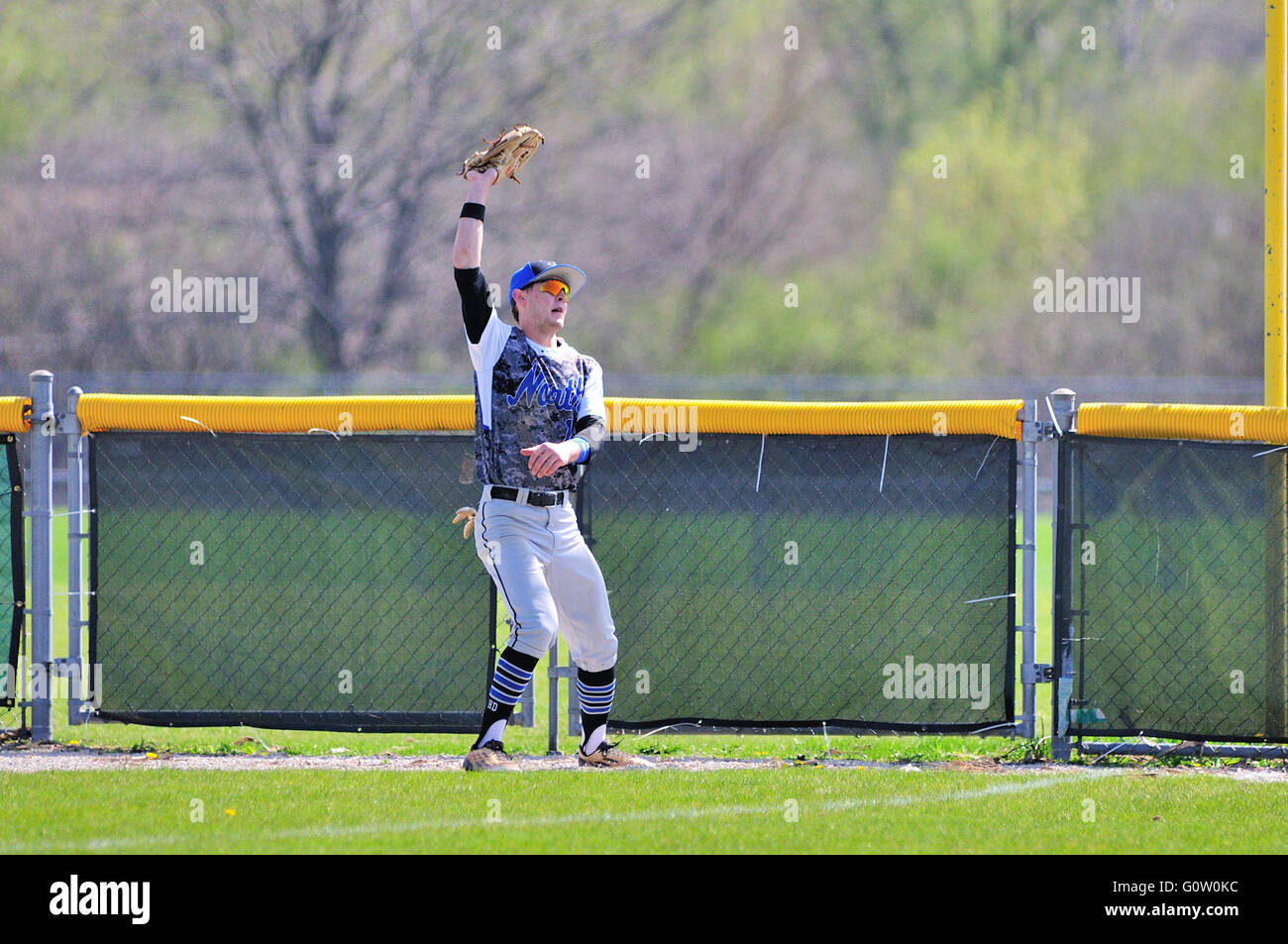 Una scuola di diritto fielder tira in una profonda fly sfera sull'avviso via e nei pressi del fallo pole. Stati Uniti d'America. Foto Stock