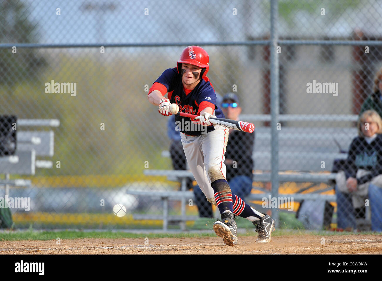 Mancino pastella spingendo un bunt verso il basso della terza linea di base durante una scuola di gioco di baseball. Stati Uniti d'America. Foto Stock
