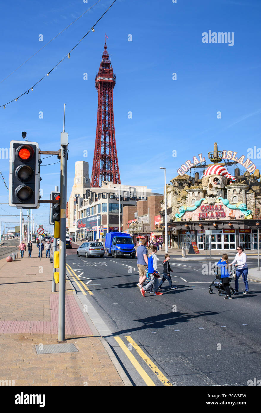 I turisti attraversare la strada come guardiamo lungo la passeggiata verso la mitica Torre di Blackpool in Blackpool, Lancashire, Regno Unito Foto Stock
