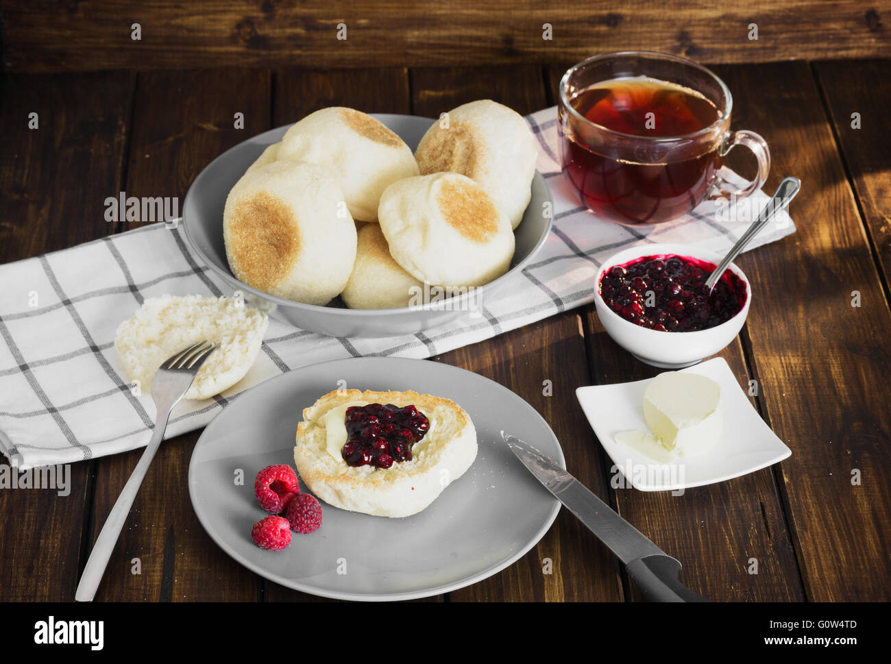 Muffin con burro e marmellata e tè su scuro dello sfondo in legno in stile rustico Foto Stock