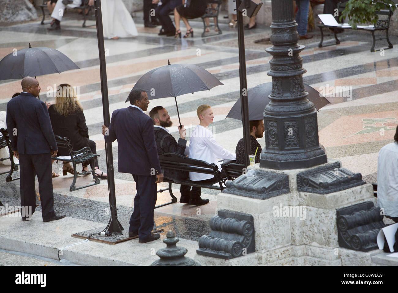L'Avana, Cuba, Cuba. Il 3 maggio, 2016. Tilda Swinton in attesa della sfilata di moda sotto l ombrello come la leggera pioggia ha ritardato il suo inizio. Il francese della casa di moda Chanel ha messo in scena il suo spettacolo nella capitale cubana Havana - il primo international fashion show fin dal 1959 la rivoluzione comunista, che ha evidenziato sia il riscaldamento i rapporti con l'Occidente ma anche nuove disuguaglianze sull'isola, dove circa il 70 percento dei lavoratori cubani lavorano per lo stato su uno stipendio medio di $ 25 ogni mese.da vetrina per la sua collezione di crociera a Cuba, Chanel ha detto che era ritornando indietro alle radici della linea, originariamente Foto Stock