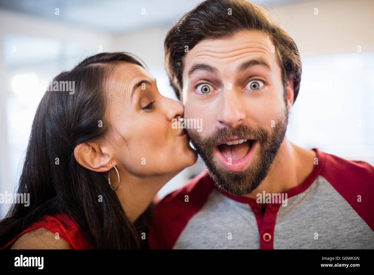 La donna che dà un bacio sulla guancia Foto Stock