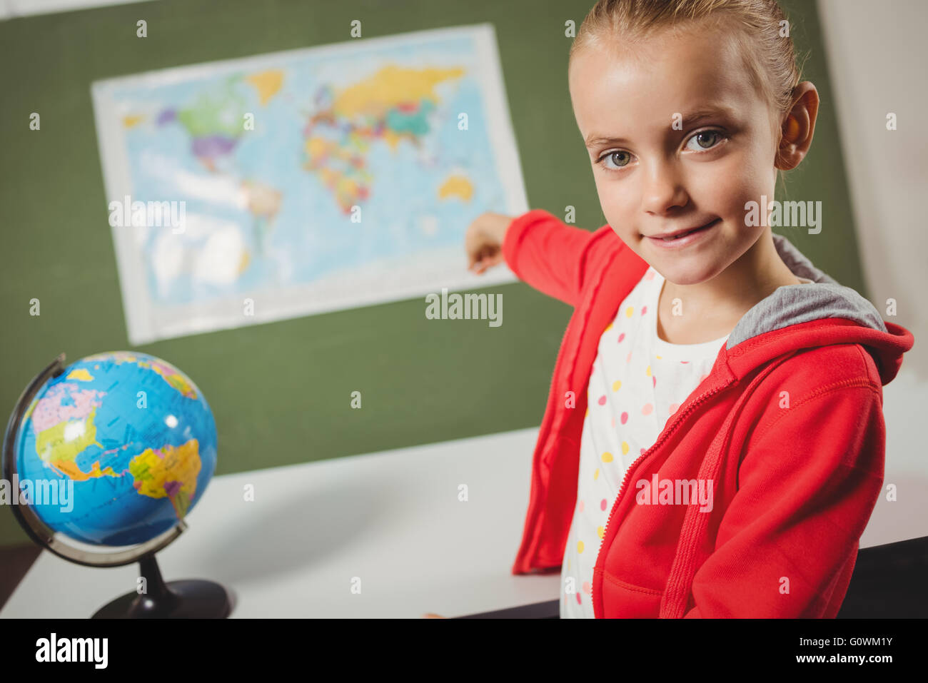 Ragazza puntando sulla mappa del mondo Foto Stock