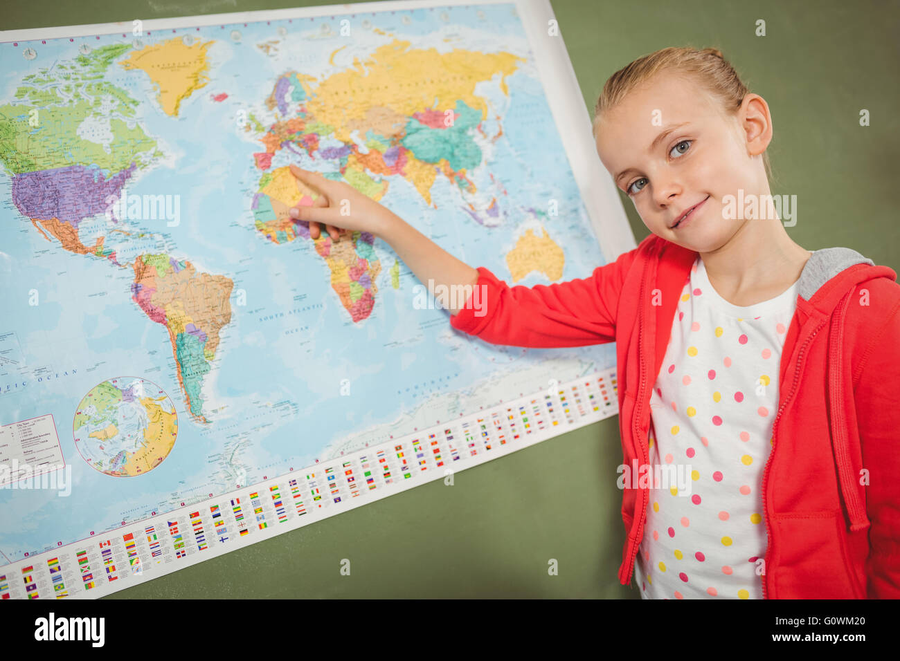 Ragazza puntando sulla mappa del mondo Foto Stock