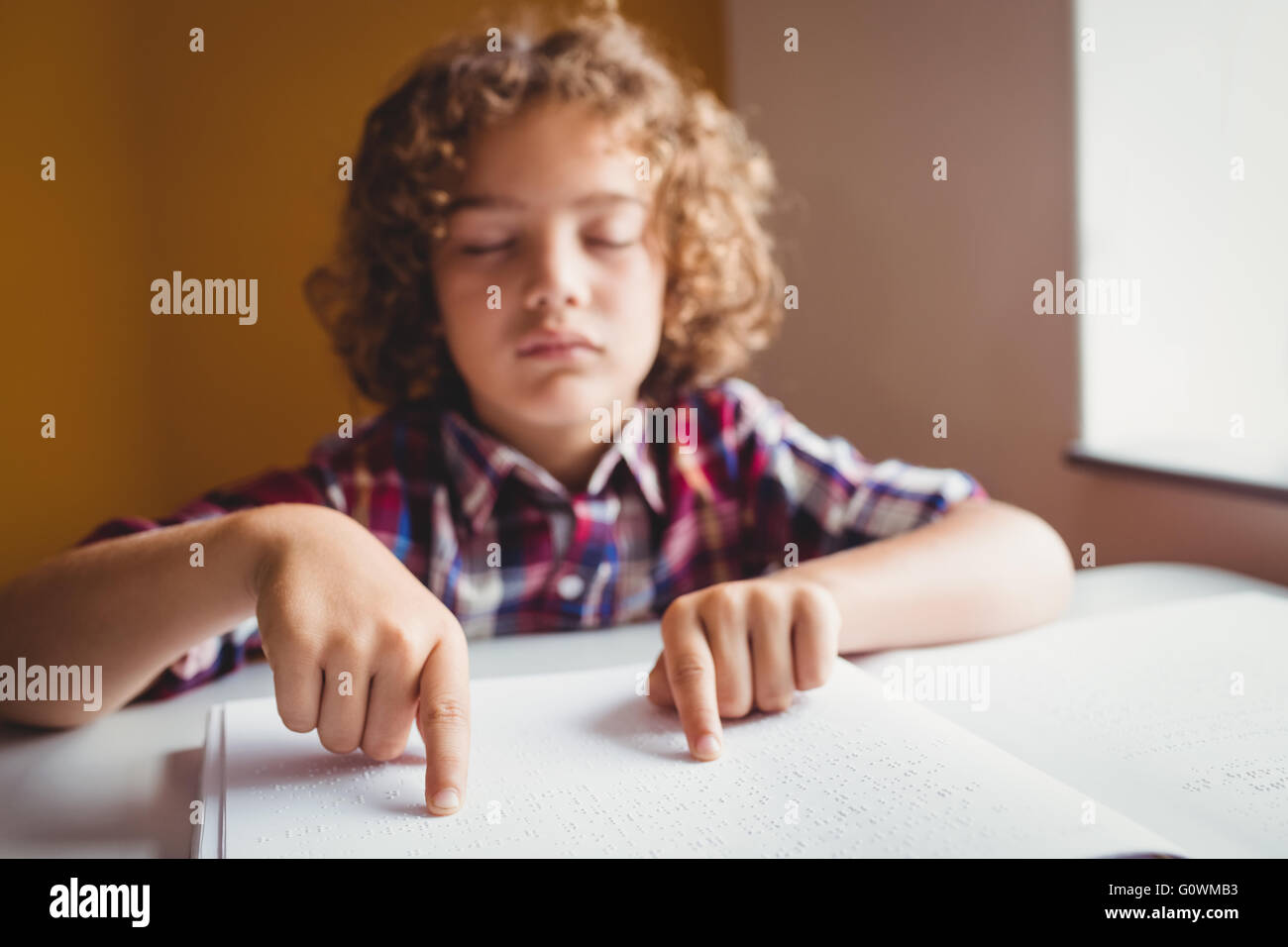 Boy utilizzando il braille per leggere Foto Stock