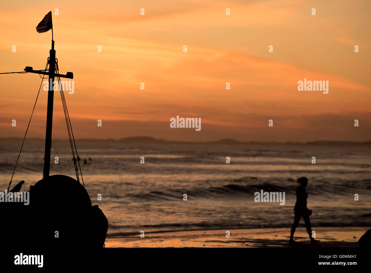 La baia di spiaggia paesaggio al tramonto del tempo, vacanze estive paesaggi con barche a vela silhouette e turisti. Foto Stock