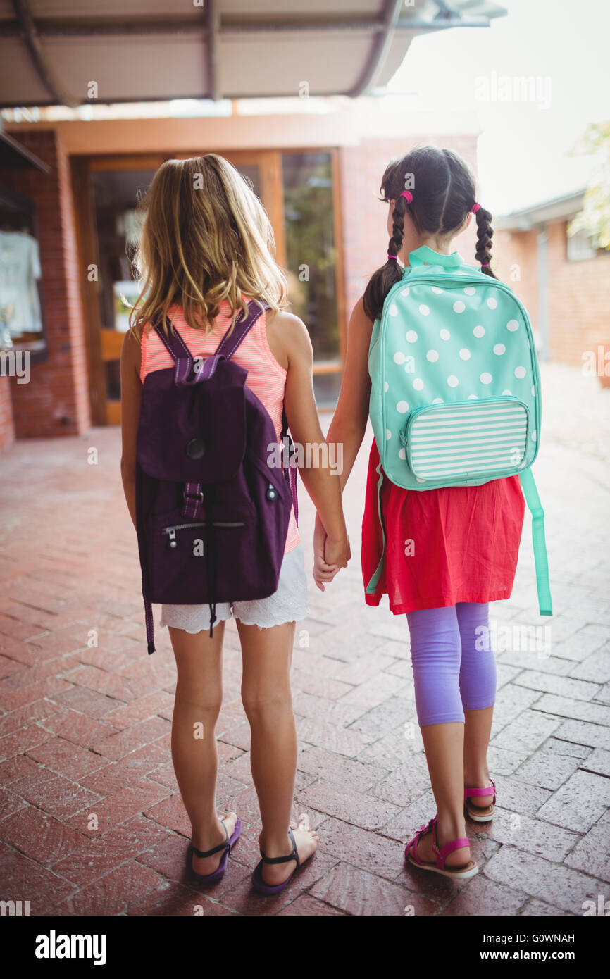 Vista posteriore di due bambine di andare a scuola Foto Stock