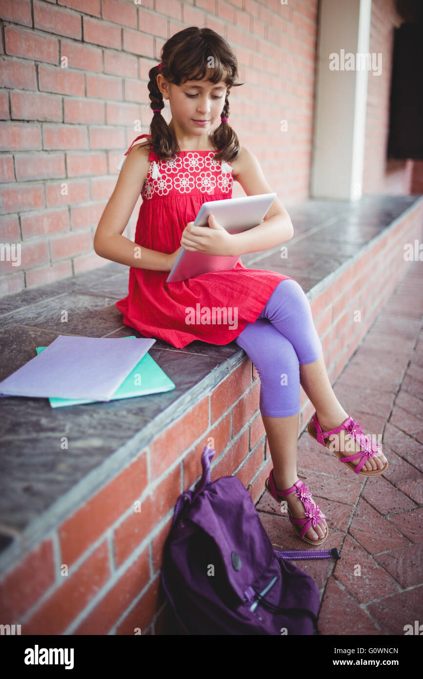 Schoolgirl guardando lei tavoletta digitale Foto Stock