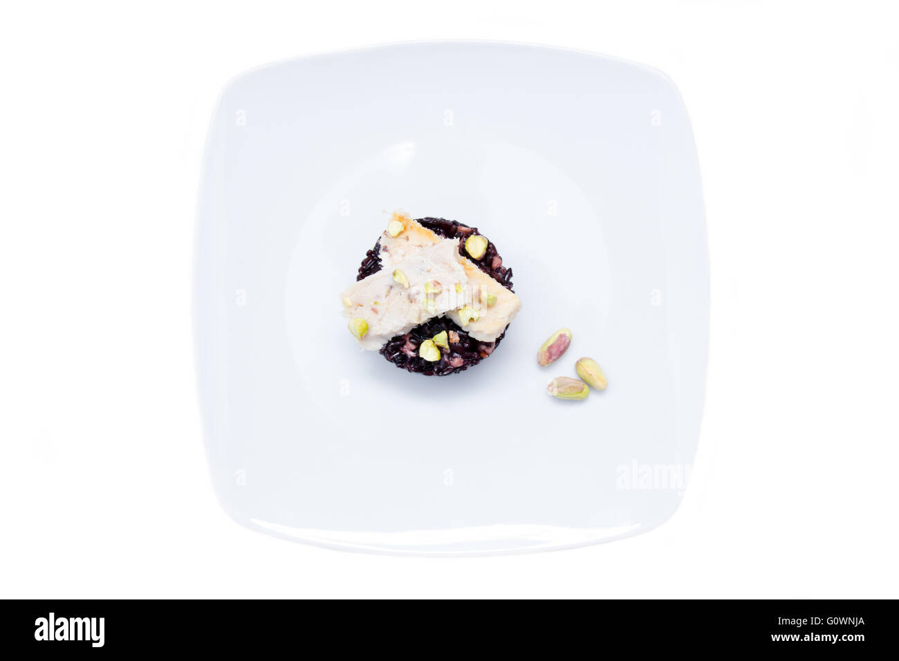 Il riso nero con pesce e pistacchi su uno sfondo bianco visto da sopra Foto Stock