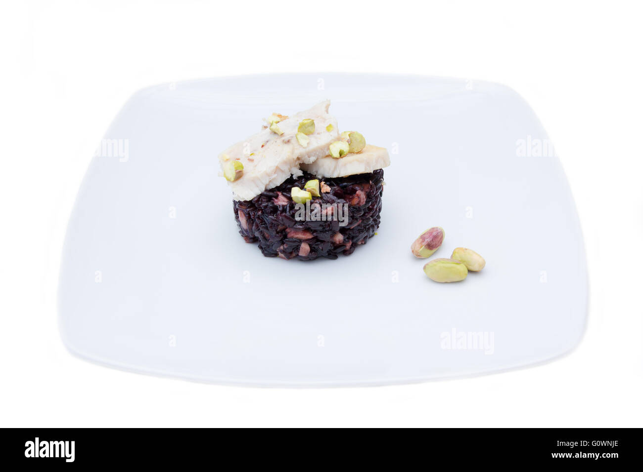 Il riso nero con pesce e pistacchi su sfondo bianco Foto Stock