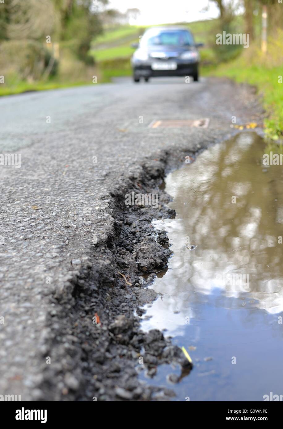 Buche nelle strade rurali di diventare un grosso problema per gli automobilisti Foto Stock