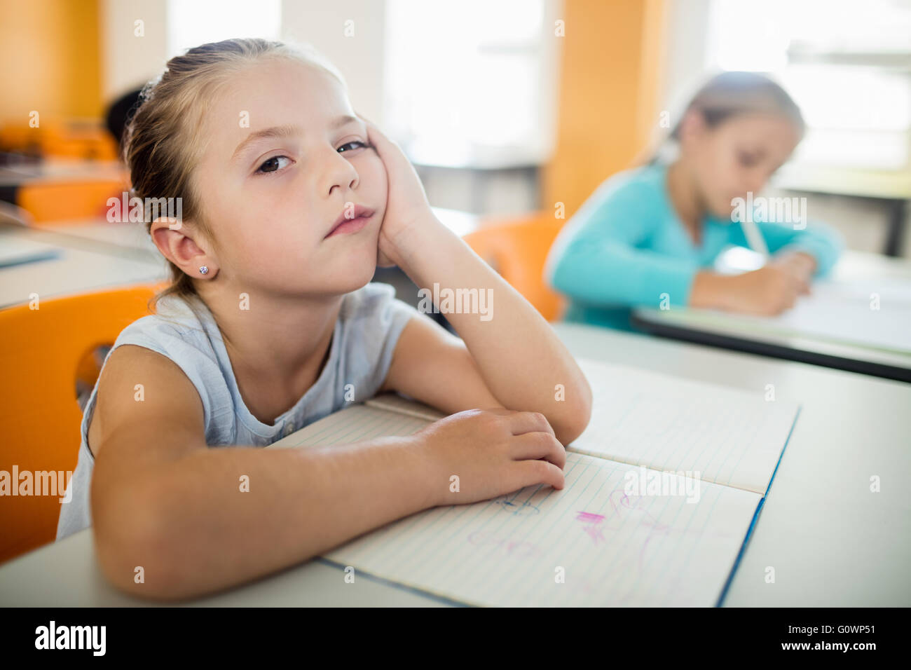 Annoiati poco ragazza seduta Foto Stock