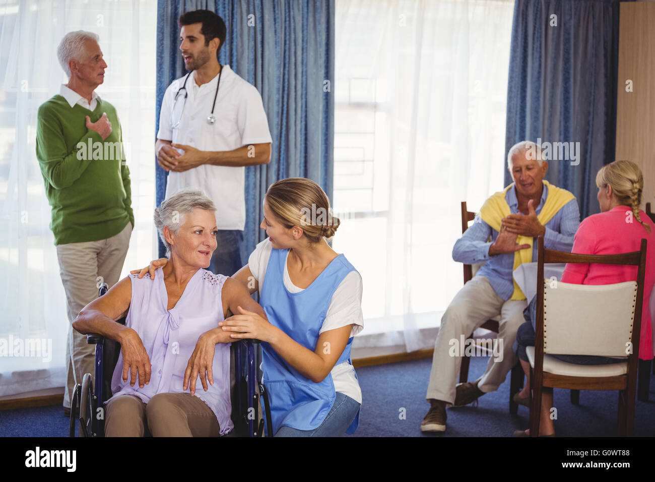 Infermieri con discussioni con i pazienti anziani Foto Stock