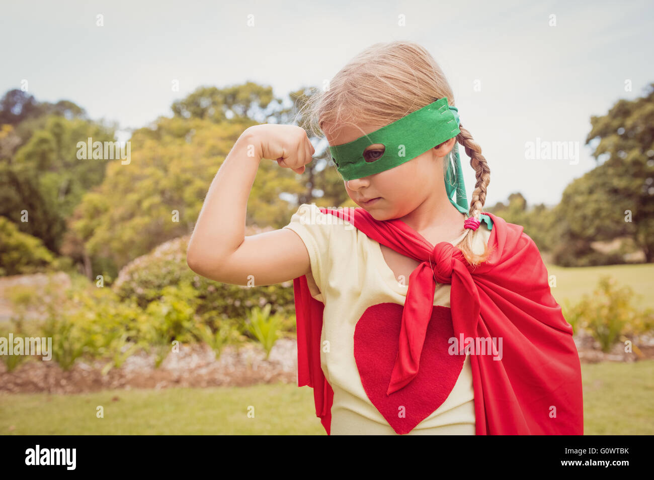 Bambina indossa costume da supereroe parti bicipite Foto Stock