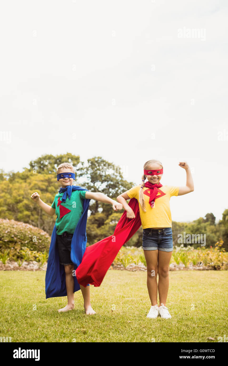 Vista frontale dei bambini che indossano il costume del supereroe in posa per la fotocamera Foto Stock