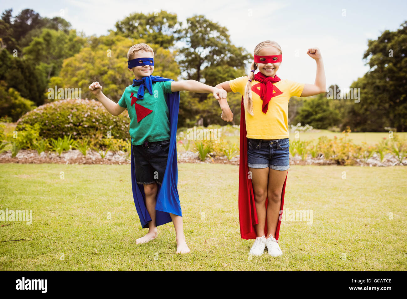 Vista frontale dei bambini che indossano il costume del supereroe in posa per la fotocamera Foto Stock