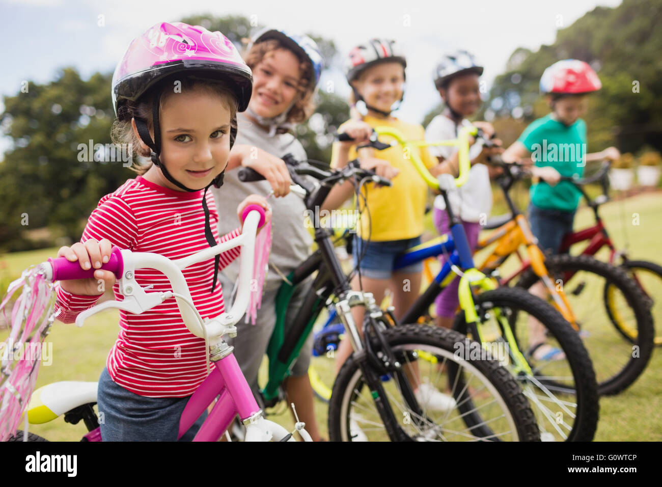 Bambini sorridenti in posa di materie con bici Foto Stock
