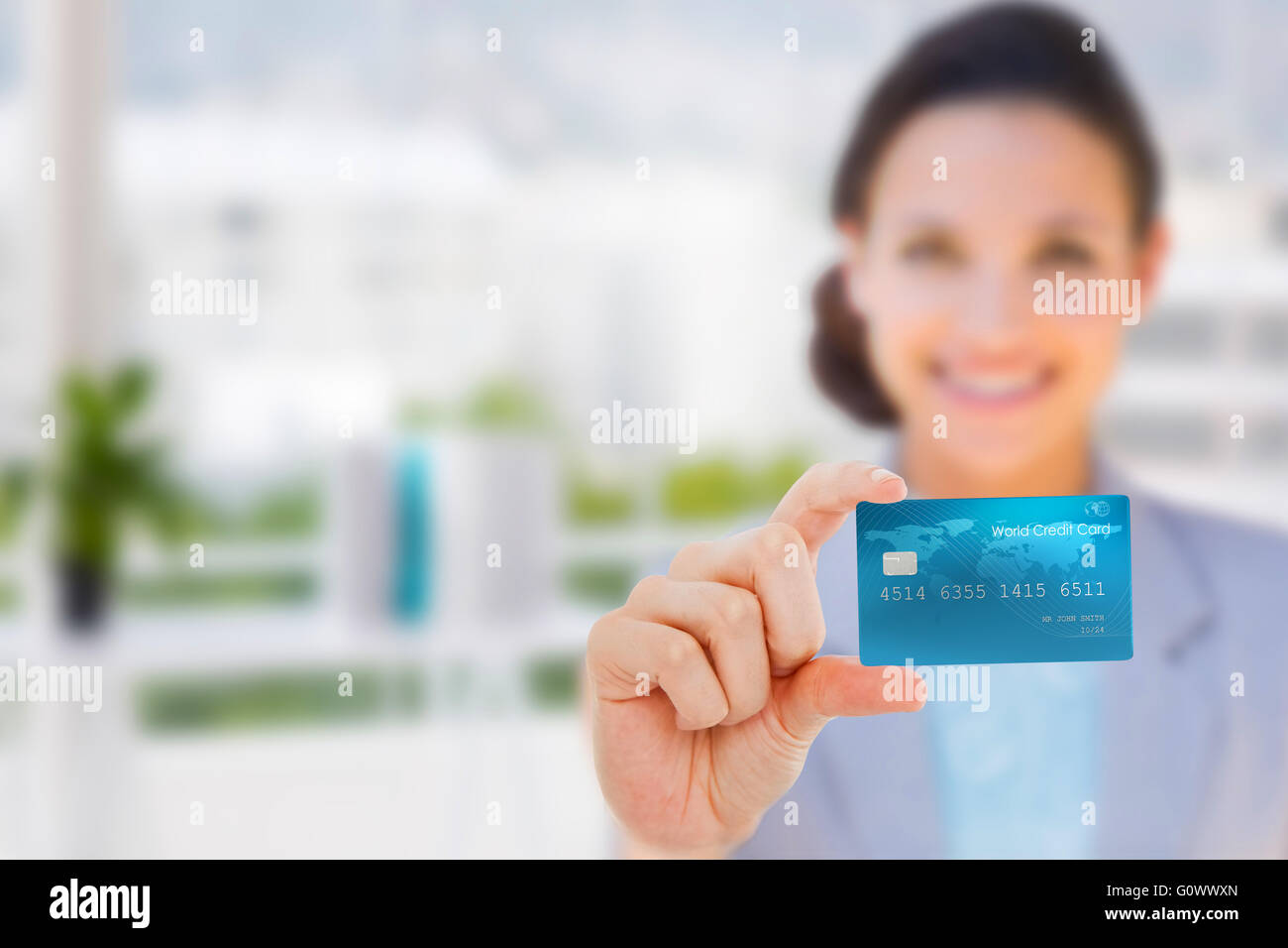 Immagine composita di felice imprenditrice che mostra una carta di credito Foto Stock