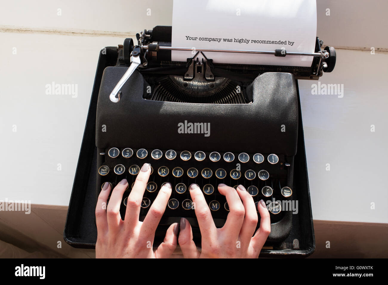 La vostra azienda è stata altamente raccomandato da contro mano womans digitando su una macchina da scrivere Foto Stock
