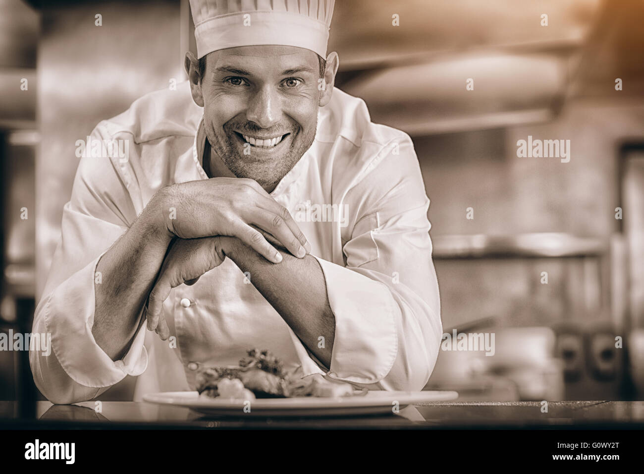 Sorridente chef maschio con cibi cotti in cucina Foto Stock