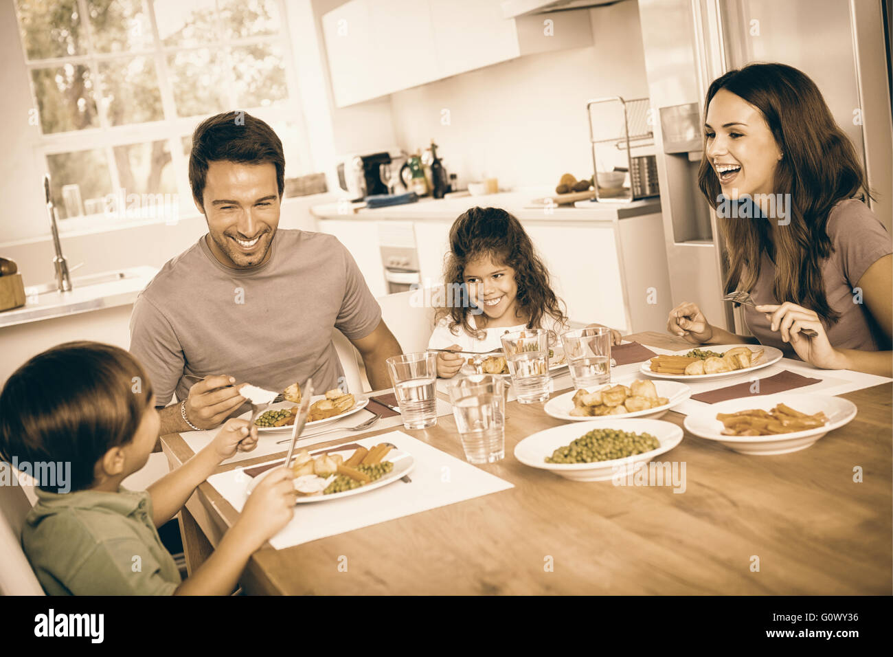 Famiglia di ridere intorno a un buon pasto Foto Stock
