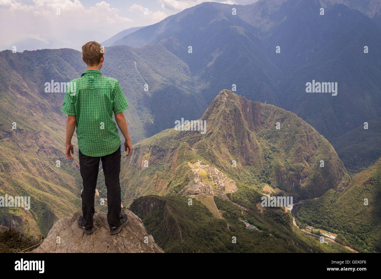 Un turista di Machu Picchu è di montagna che guarda la misteriosa città Inca di 600m sotto - Machu Picchu, Perù nel mese di ottobre 2015 Foto Stock