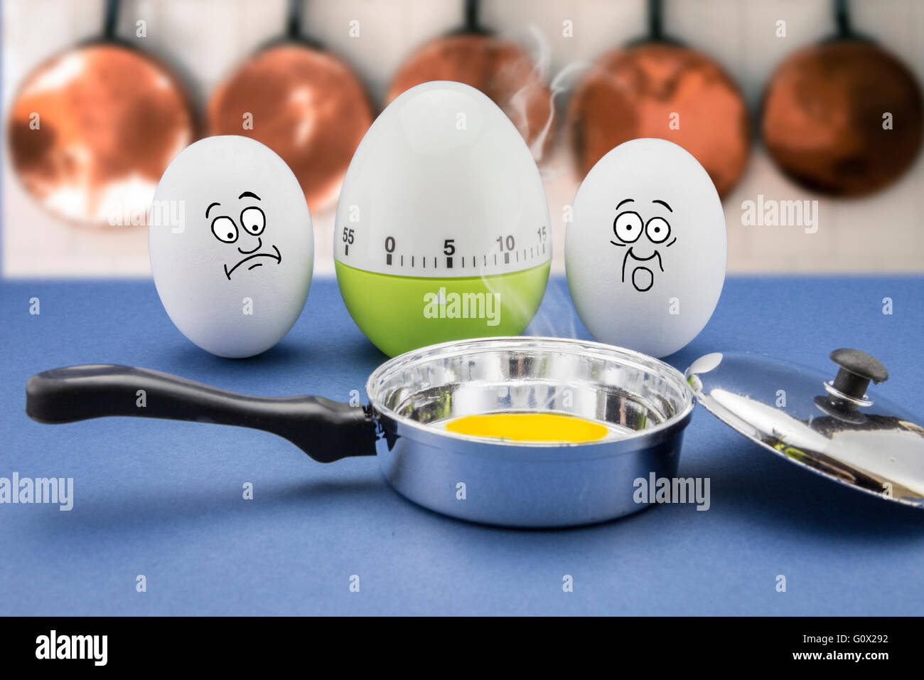 Due uova con faccia spaventata guardare una padella in una cucina Foto Stock