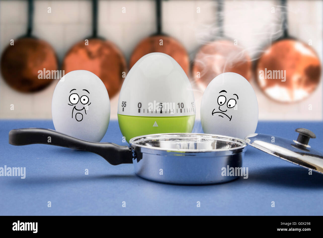 Due uova con faccia spaventata guardare una padella in una cucina Foto Stock