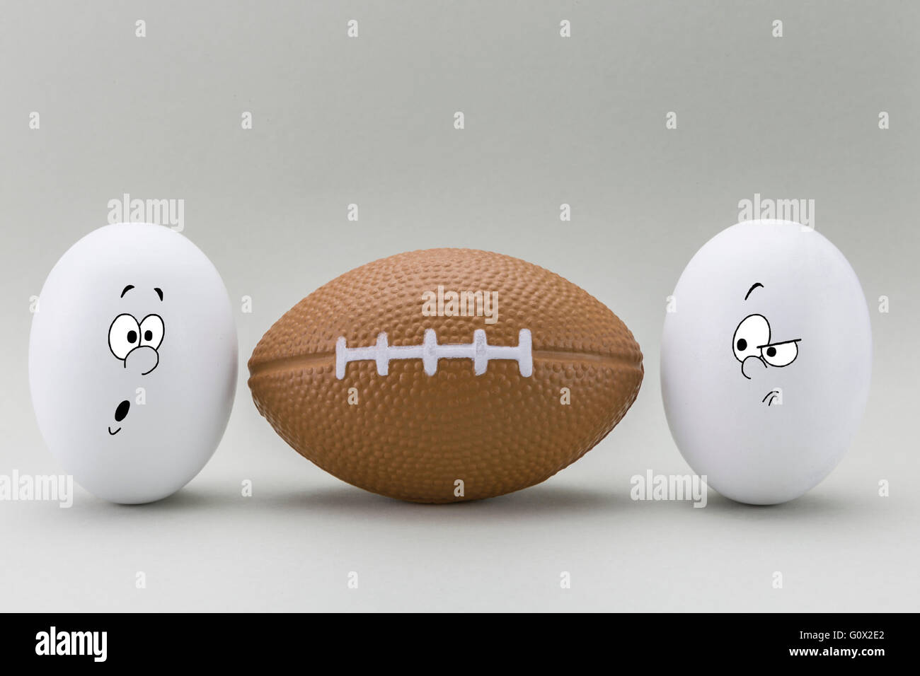 Due uova guardare con faccia strana per un palloncino di rugby Foto Stock