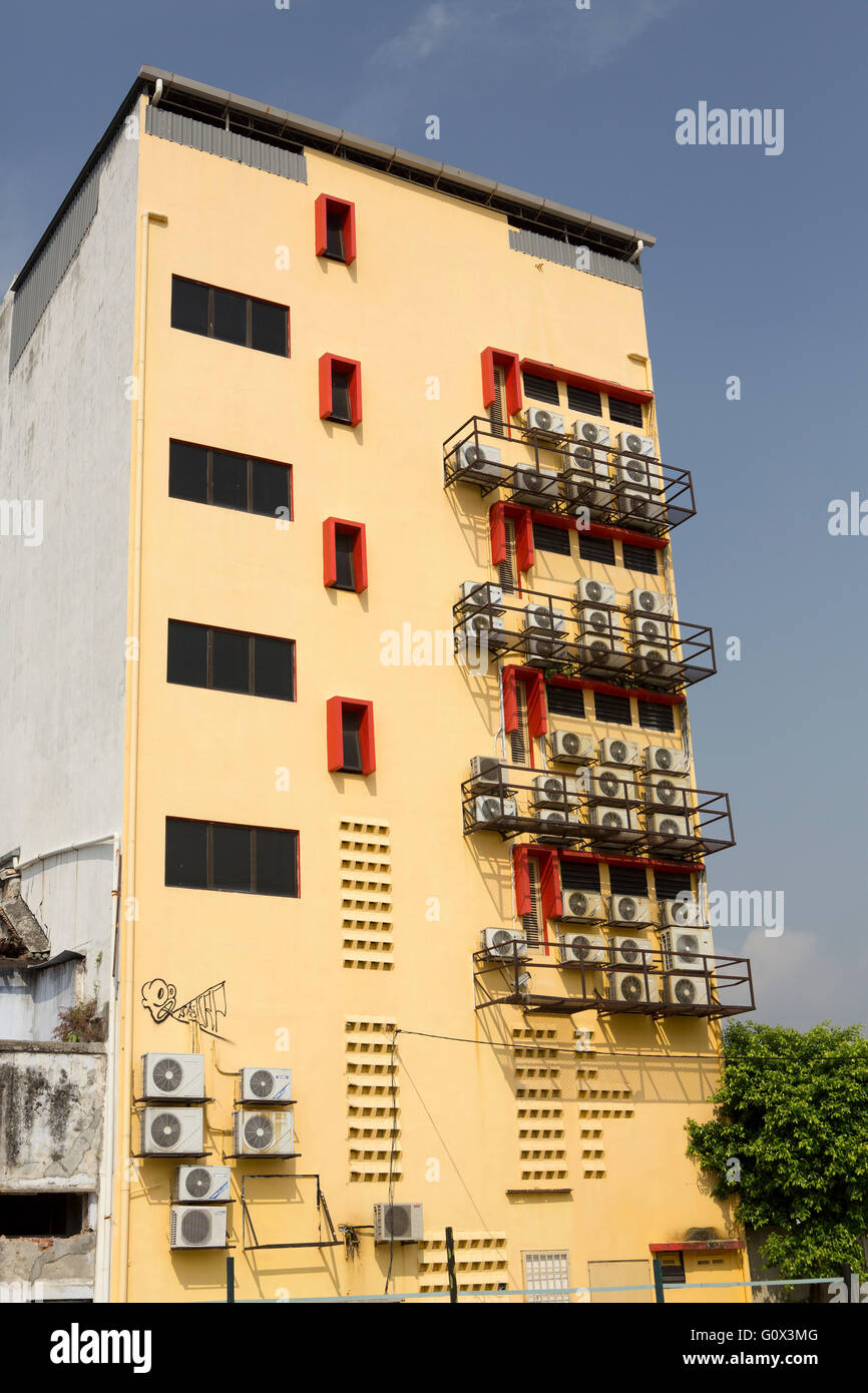 Aria condizionata edificio nei tropichi. Parete piena di aria condizionata su una parete di colore giallo di un isolato a torre. Foto Stock