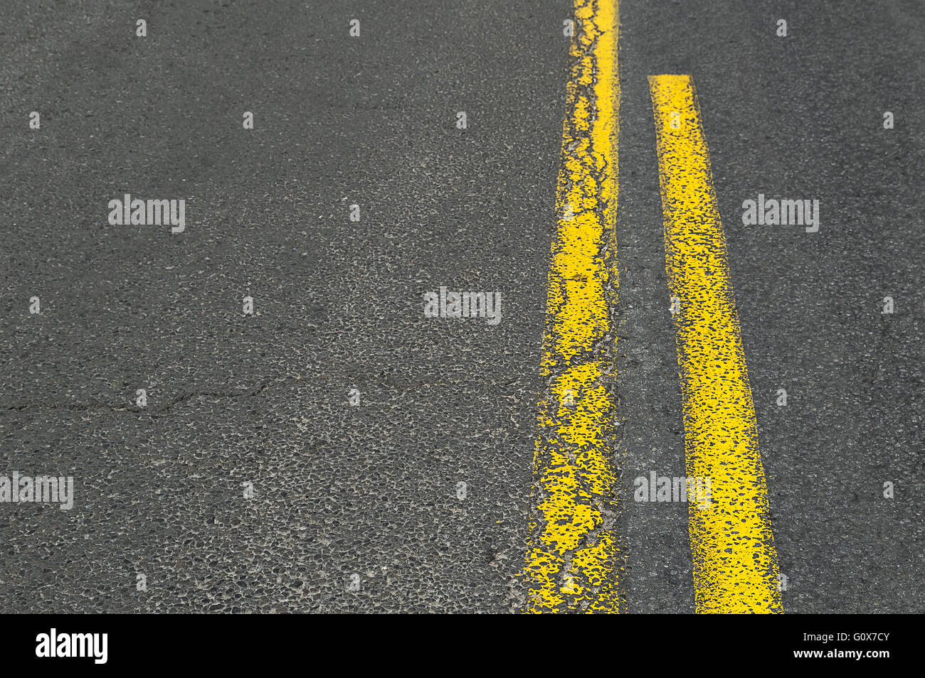 Doppio giallo linea grunge su strada asfaltata. Foto Stock