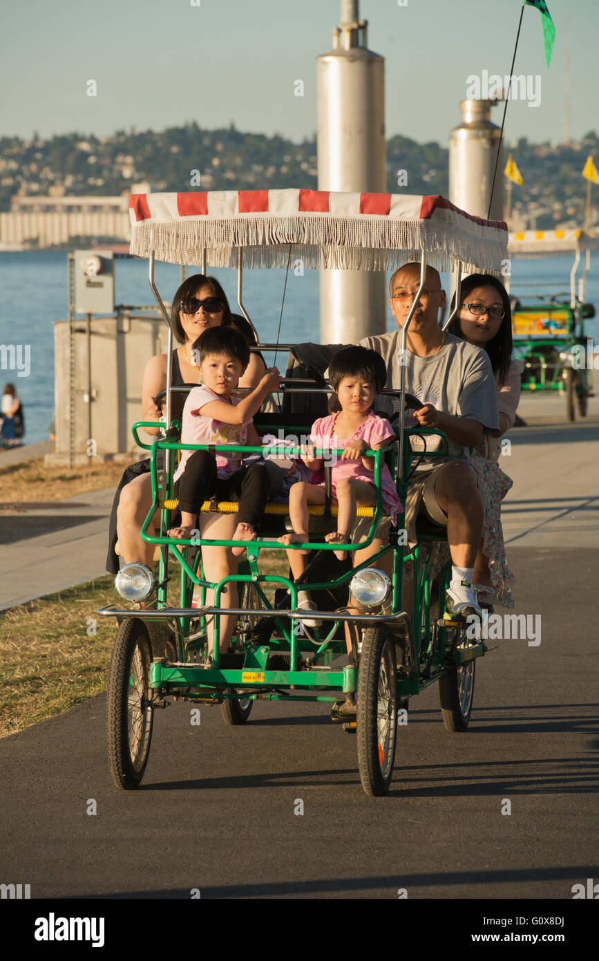 Famiglia pedale giostre surrey, Alki Beach, Puget Sound, Seattle, Washington ESTATE Foto Stock