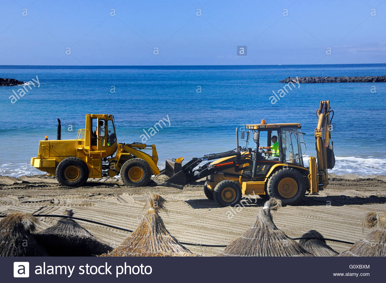 macchina pulizia arenile spiaggia Trattori-giallo-pulizia-spiaggia-playa-de-las-americas-tenerife-isole-canarie-g0xbxm