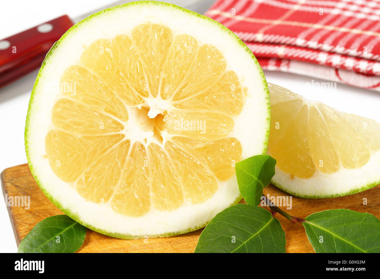 Dettaglio di fettine di pompelmo verde sul tagliere di legno Foto Stock