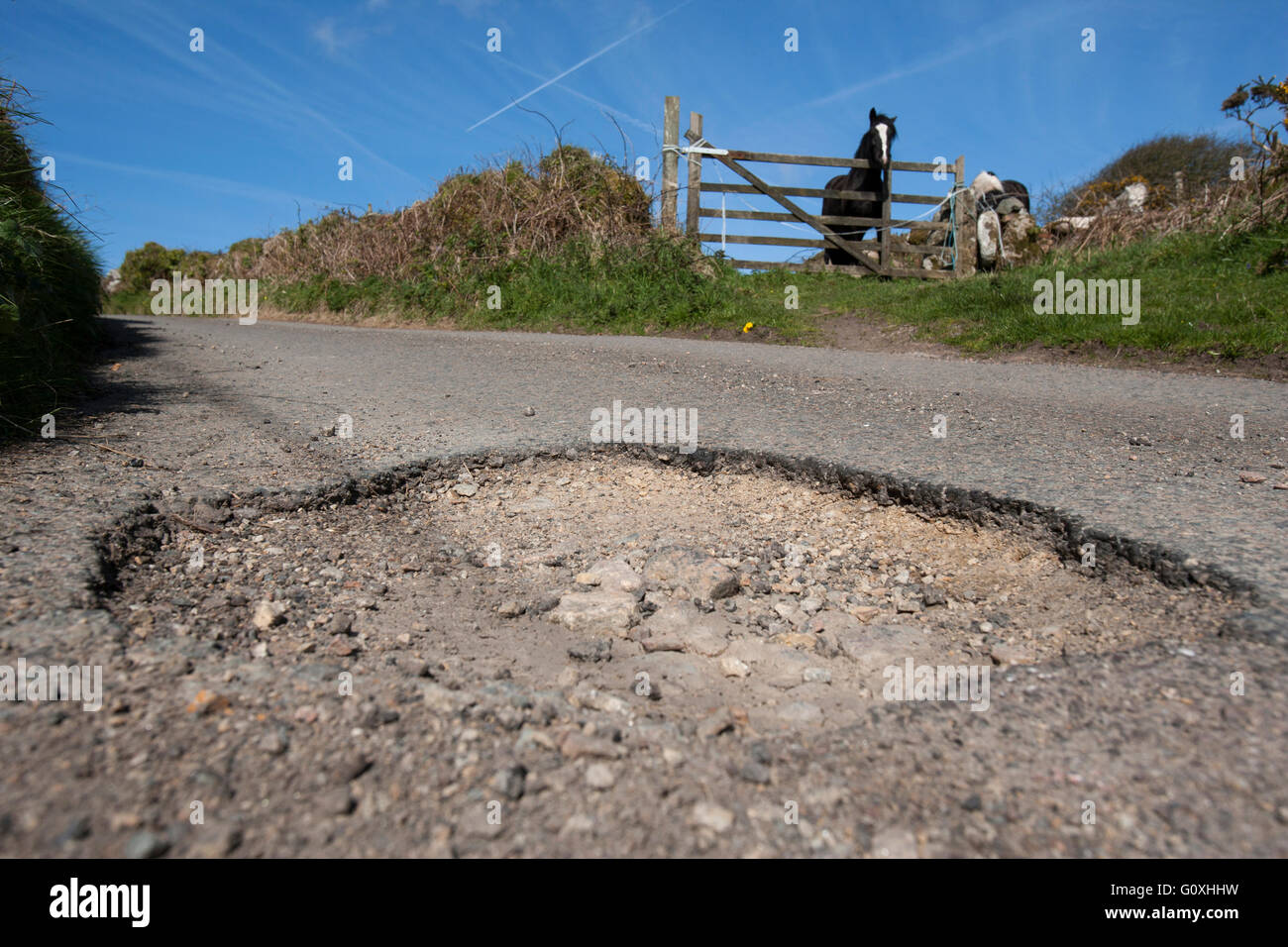 Campagna di buche in strada causano danni alle auto e sono un pericolo per gli ignari motociclisti e ciclisti buca Foto Stock