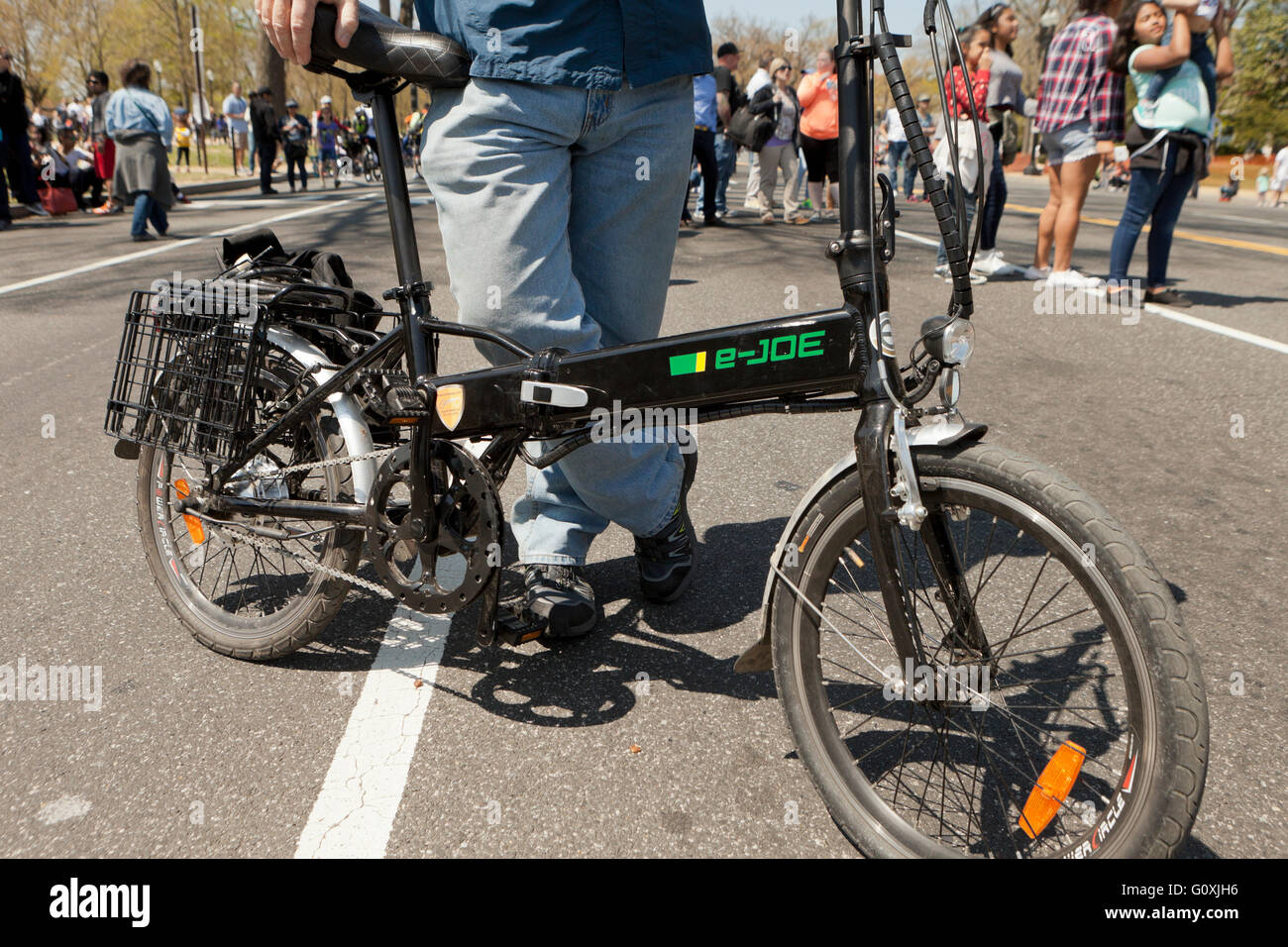 Uomo in piedi accanto a una piegatura della bicicletta elettrica - USA Foto Stock
