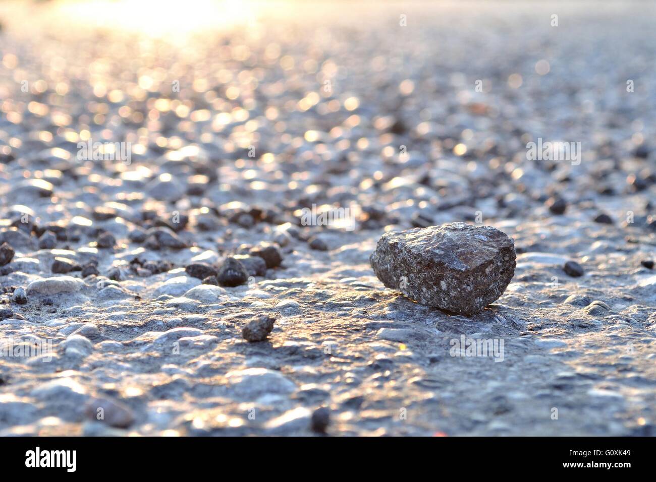 Una roccia su asfalto con luce da angolo superiore sinistro Foto Stock