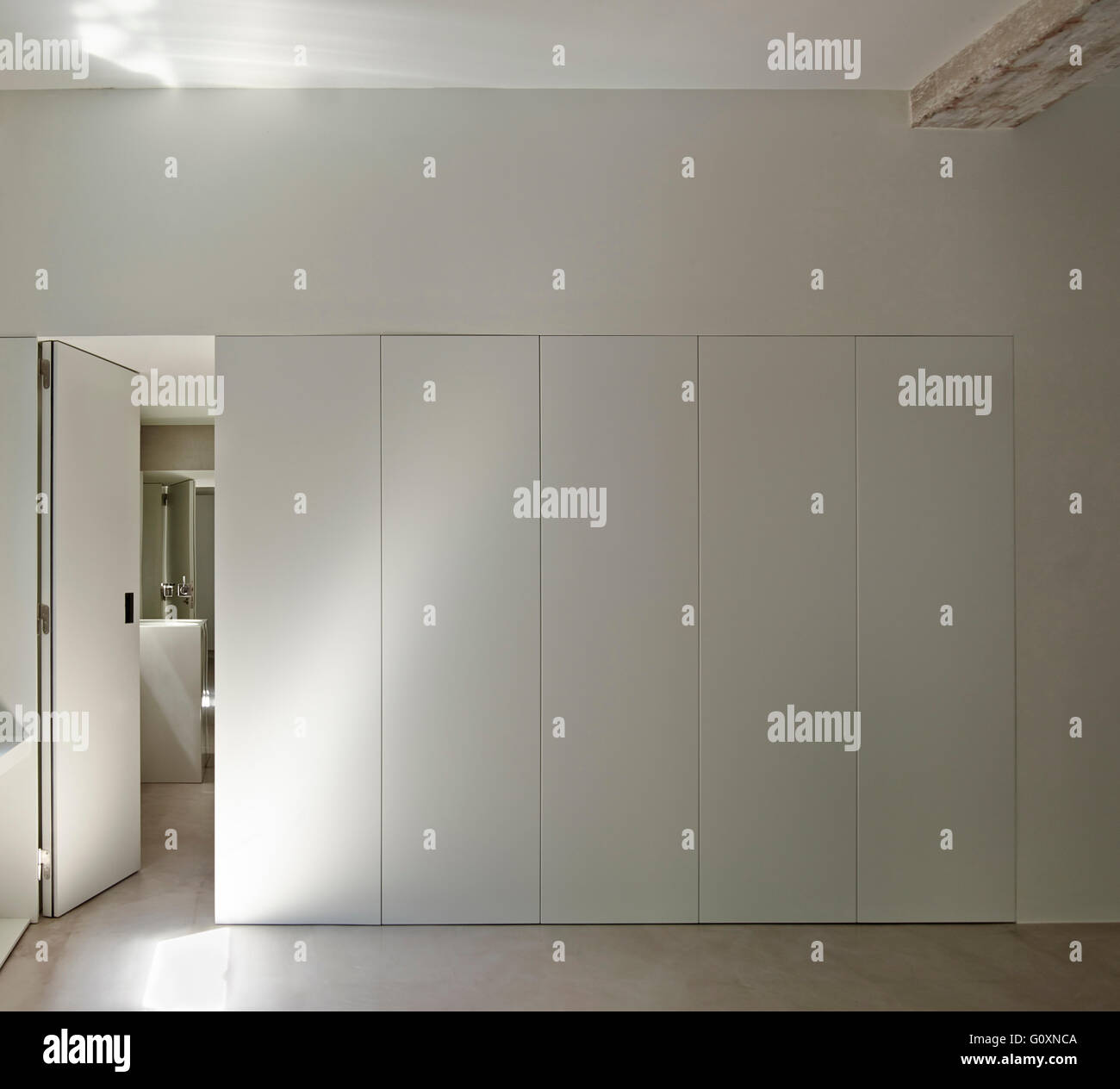 Camera grande con tutte le pareti bianche e pavimenti in legno. Foto Stock