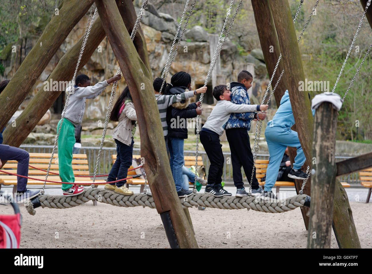 Sette bambini su una corda swing Foto Stock
