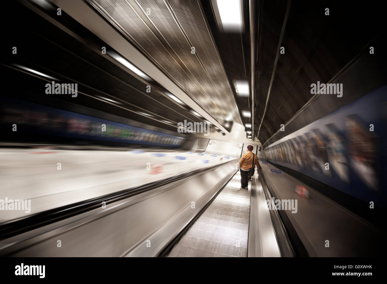 SCALA MOBILE MOBILE con la figura solitaria che scende. Metropolitana di Londra Regno Unito Foto Stock