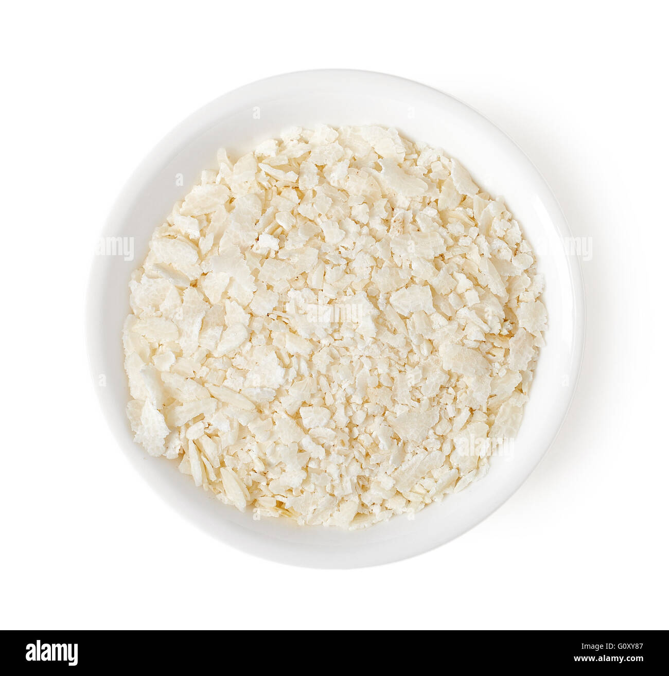 Ciotola di appiattita fiocchi di riso isolato su sfondo bianco, vista dall'alto Foto Stock