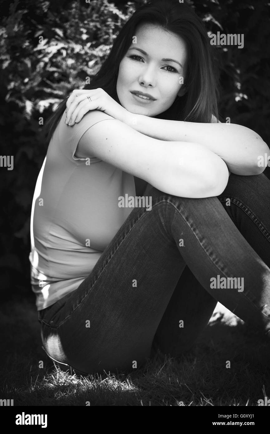 Ritratto di una rilassata donna felice al di fuori di un ponticello e jeans Foto Stock