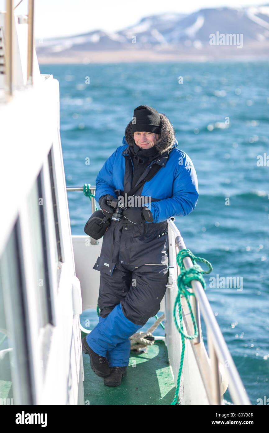 Un turista su un whale watching tour indossando spessi tuta termica in Islanda Foto Stock