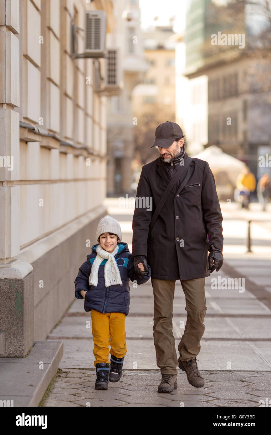 Padre e figlio camminando mano nella mano Foto Stock