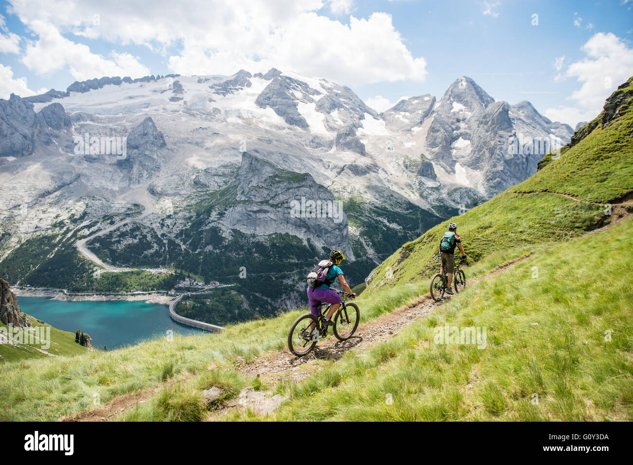 L uomo e la donna mountain bike vicino ghiacciaio della Marmolada, Dolomiti, Italia Foto Stock