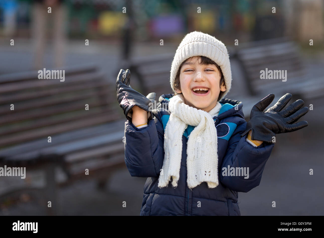 Ragazzo che indossa guanti sovradimensionato, ridendo Foto Stock