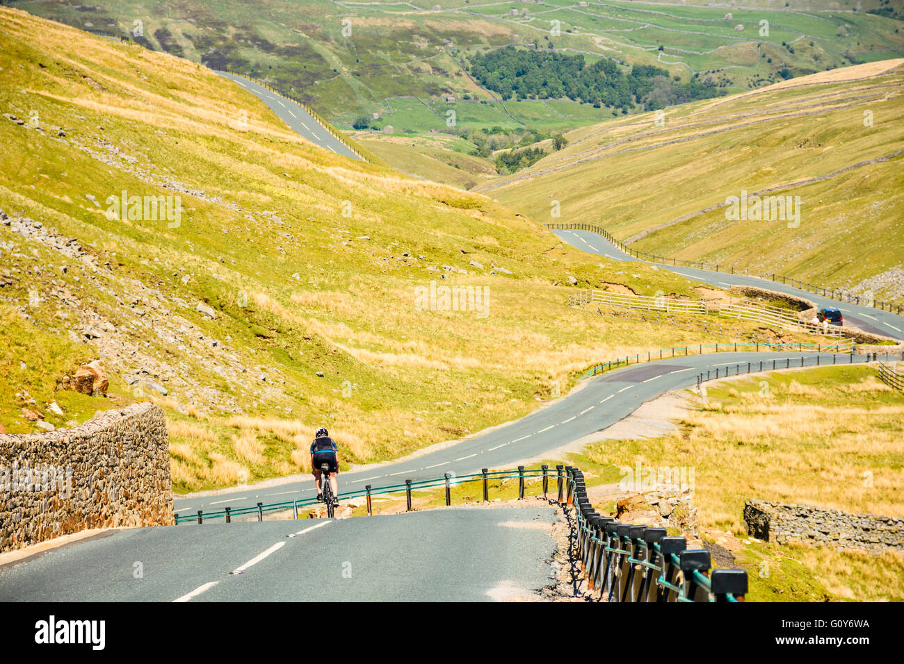 Ciclista femmina Buttertubs discendente passano sopra Swaledale nel Yorkshire Dales Foto Stock