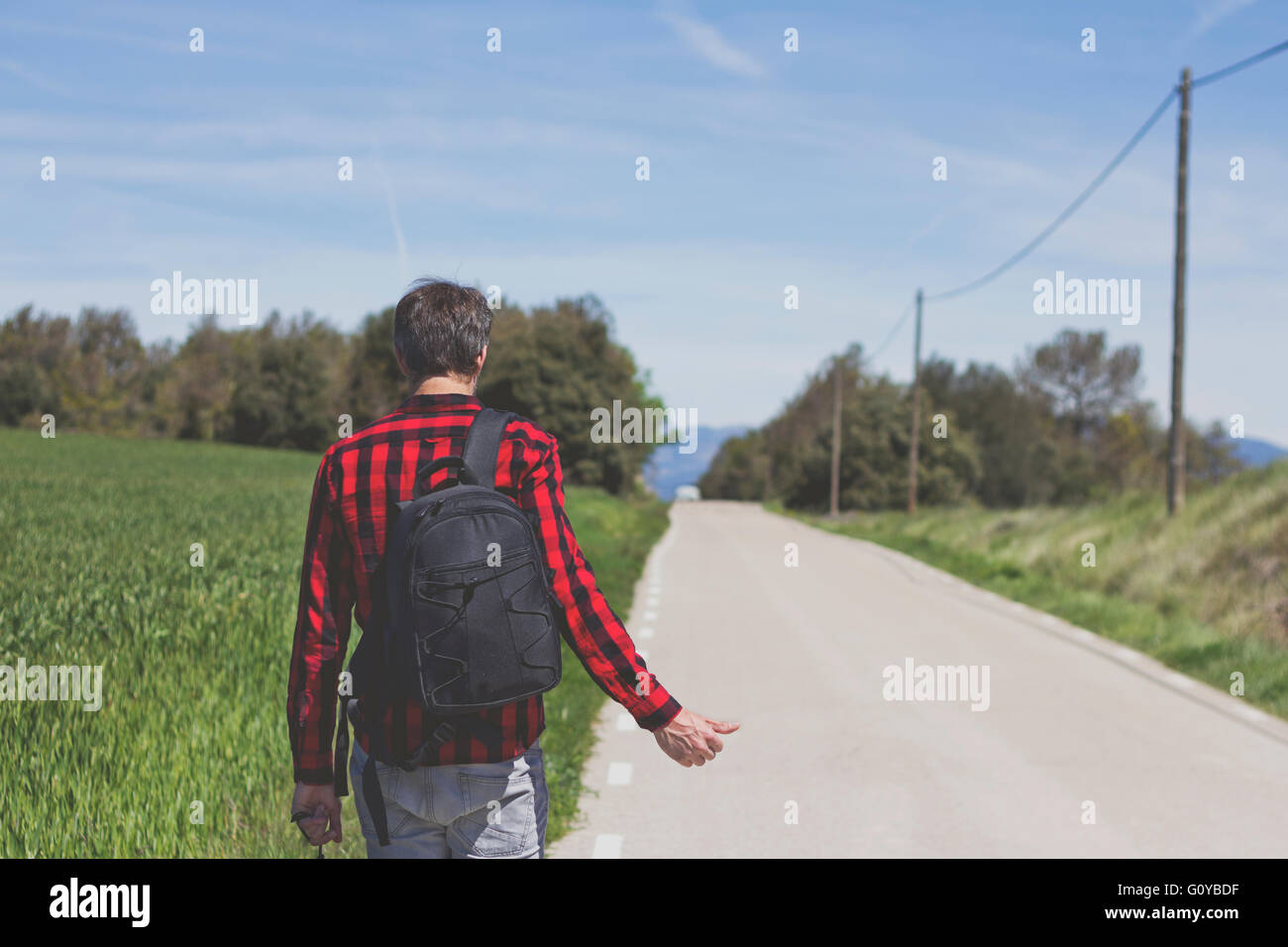 Hipster facendo autostop in strada Foto Stock