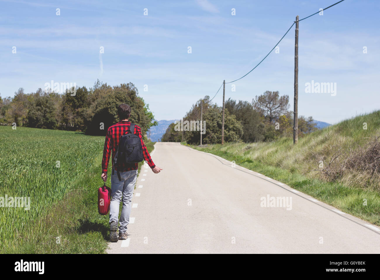 Hipster facendo autostop in strada Foto Stock